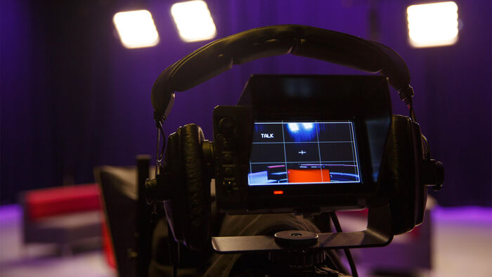 LOOKING AT A CAMERA IN A RED STUDIO