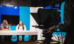 Students using a tv studio, whilst another student is using a camera and filming