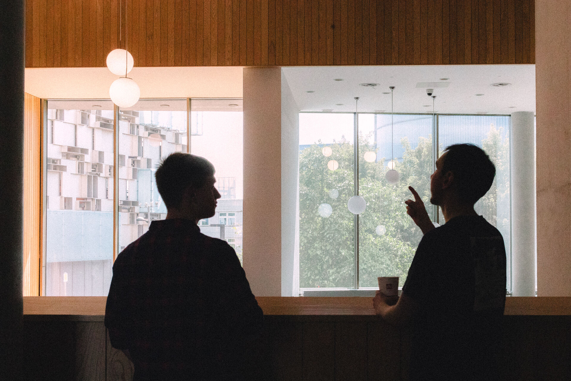 Silhouettes against Hanging lightbulbs