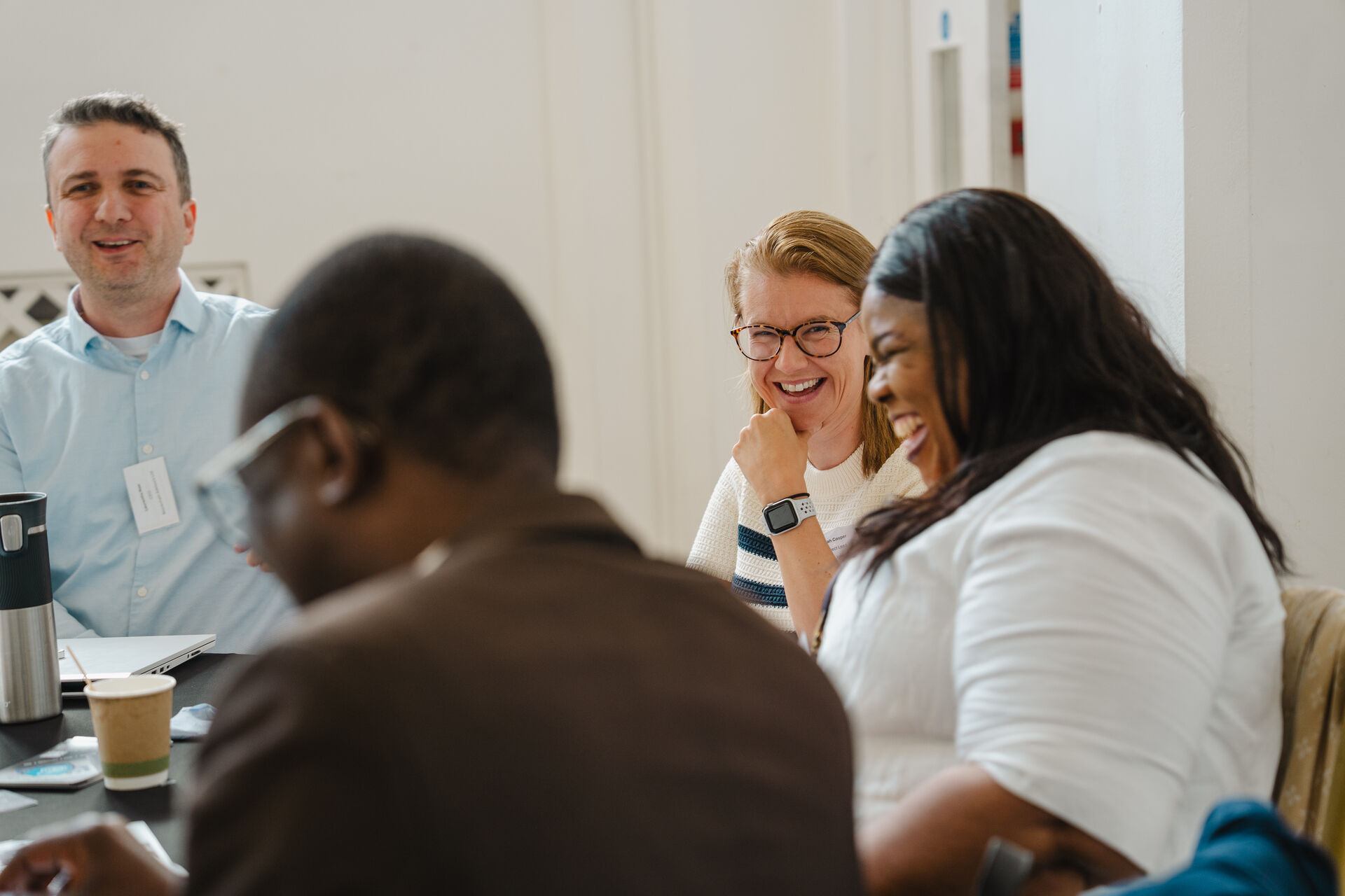 People talking and laughing at a round table for the That's Me! event