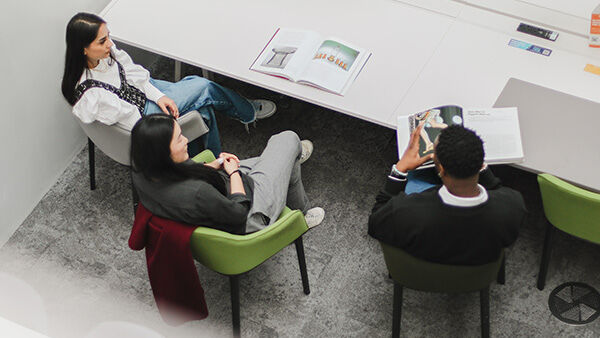 PhD Students sat around a white table in library