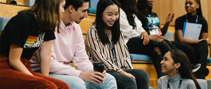 Young people talking in lecture theatre