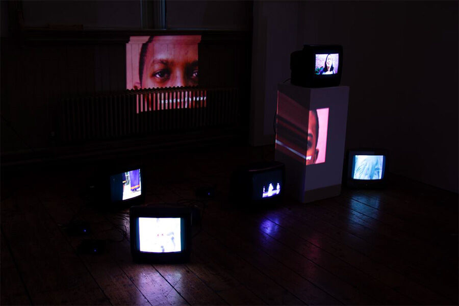 Fine Art installation: dark room with lots of old tv screens