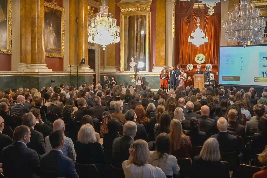 Goldsmith Craft Jewellery Award event attendees sat in rows watching presentation, at the Goldsmiths' Hall.