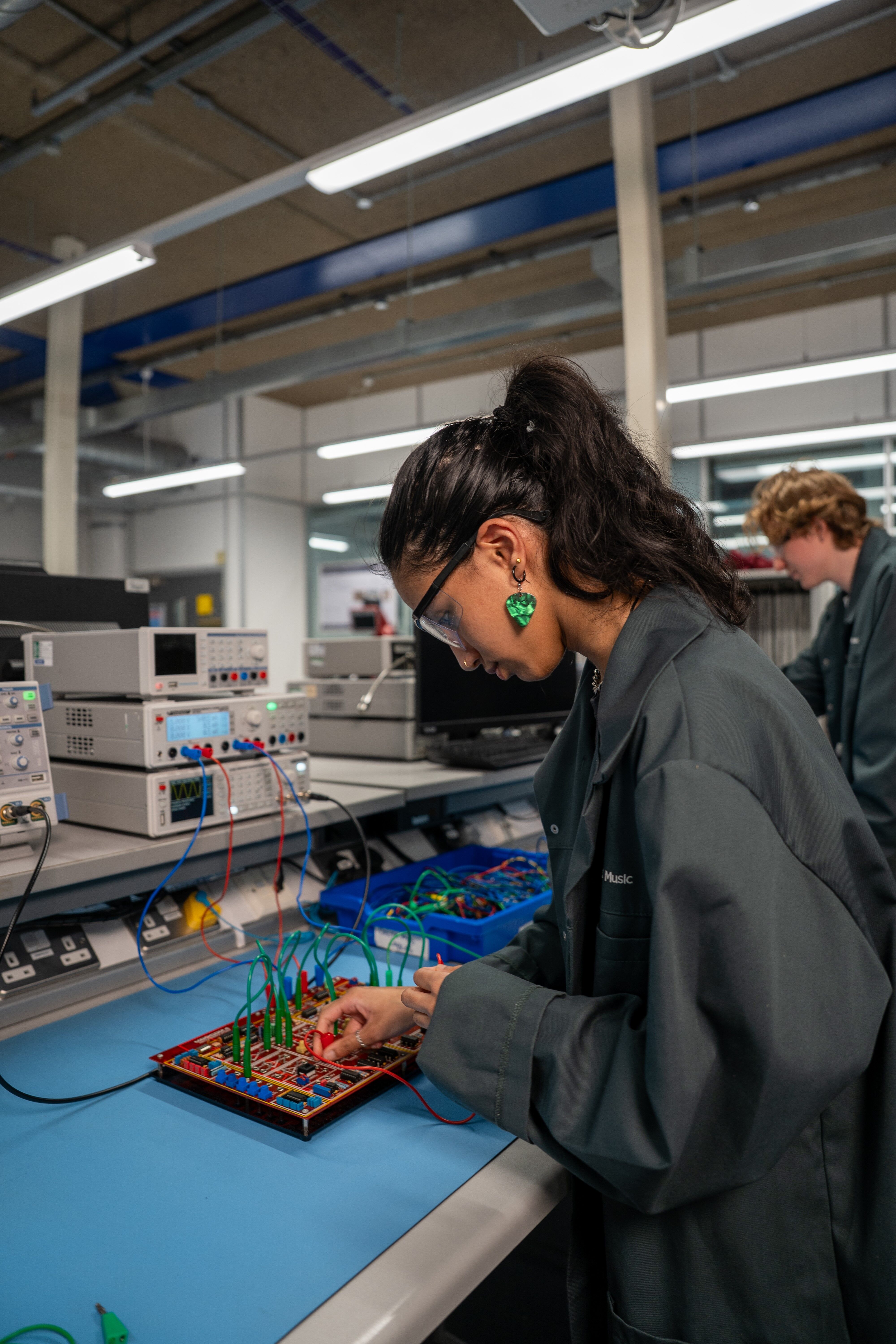 Student using sound engineering audio software/hardware wearing safety gear and goggles
