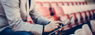 sports journalist in a football stadium with a tablet