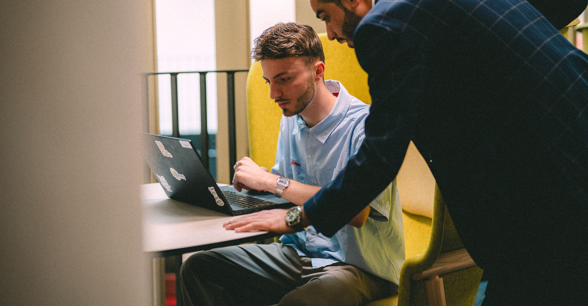 A Master's student and tutor discuss work on a laptop