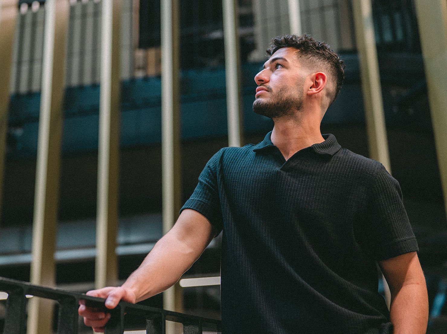 A student stands confidently looking into the foreground with a thoughtful appearance