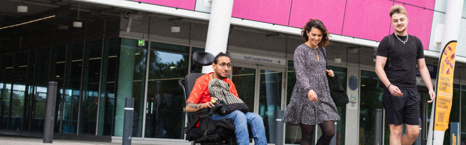 Three students walk through the Alexander Stadium campus