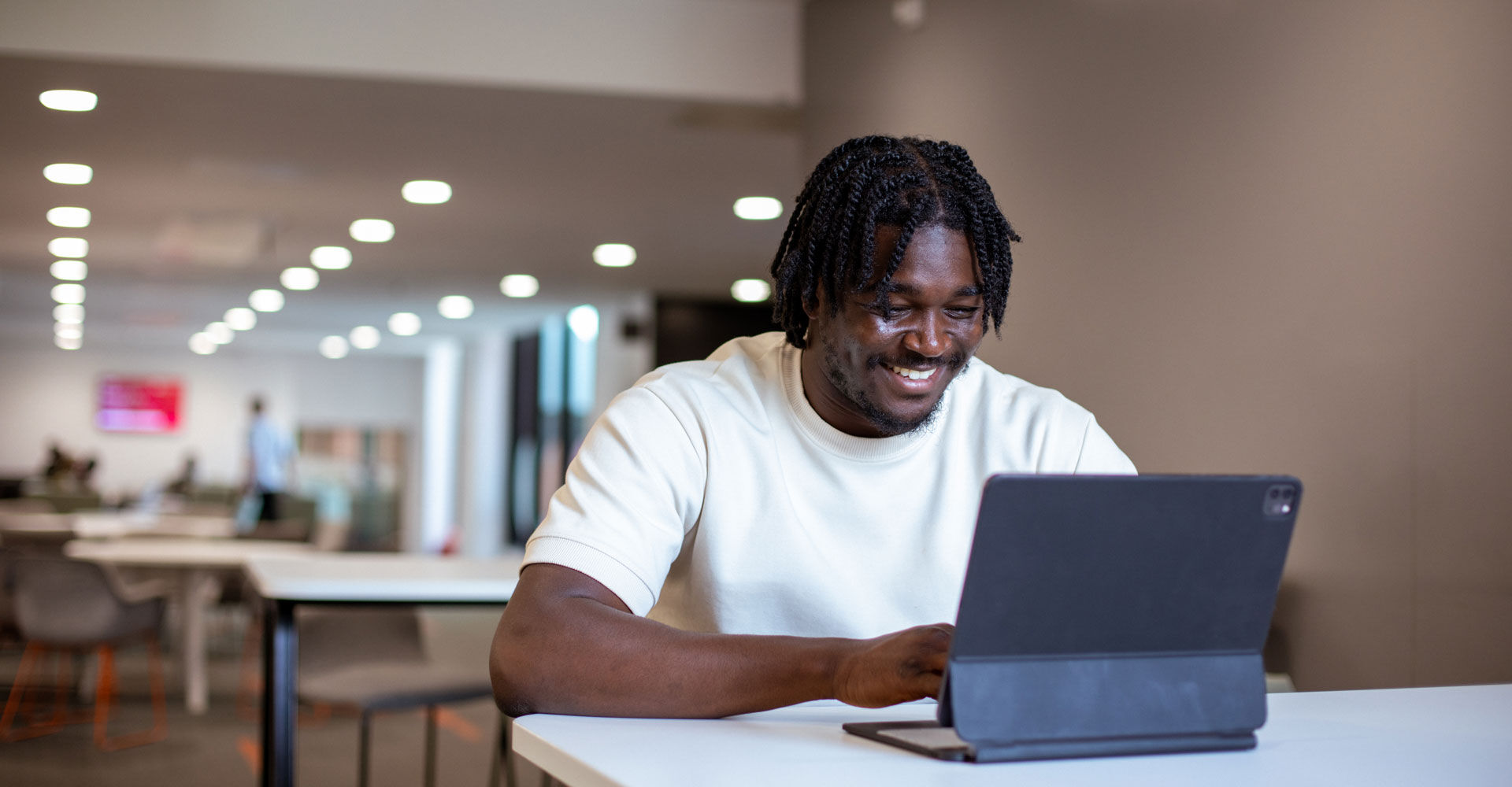 A student smiles while working on his laptop