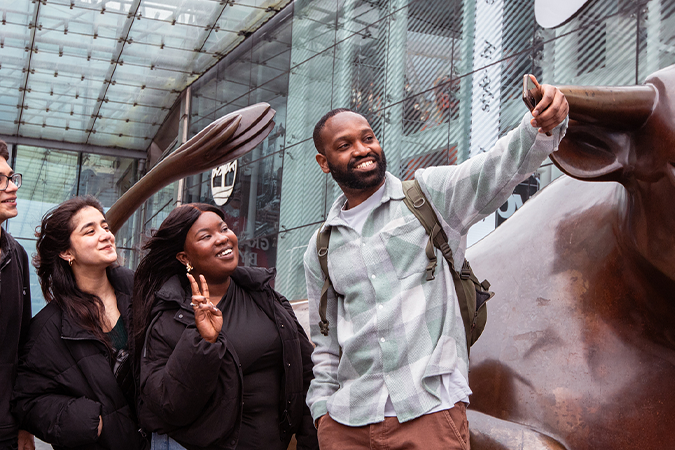 A group of students taking a selfie in front of the Bullring bull