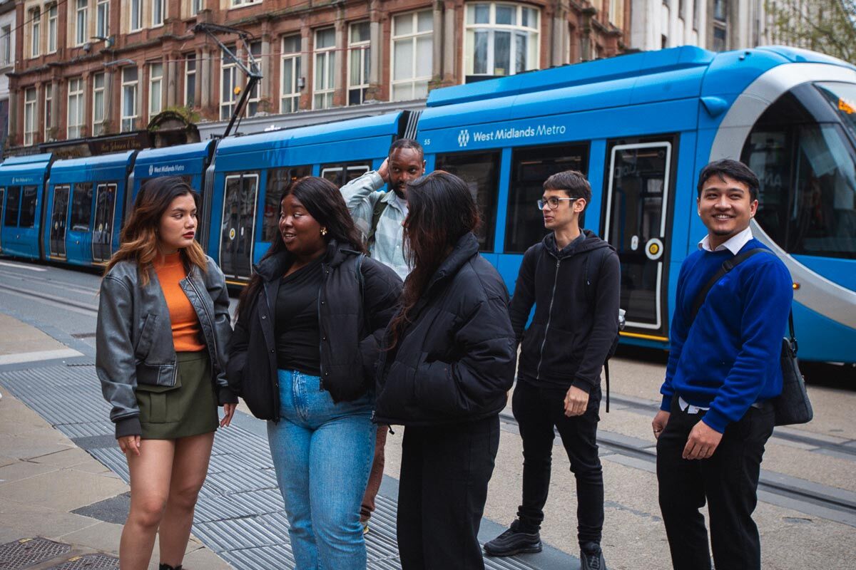 A group of students in front of a passing tram