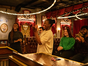 A group of students having fun playing darts at Flight Club