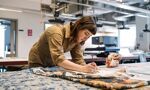 Student working on fine brushwork painting to design material