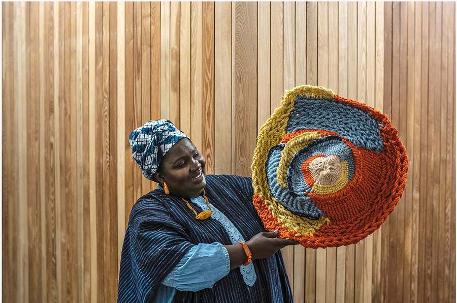 student holding up design against a wall