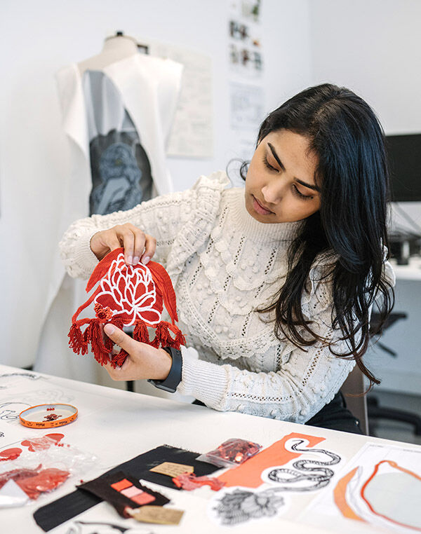 student holding up red textile design