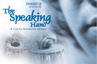 Movie poster for "The Speaking Hand," featuring the film's title in blue stylized font, a hand playing a tabla drum, and the text "A film by Sumantra Ghosal."