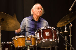 Tony Levin behind drum kit