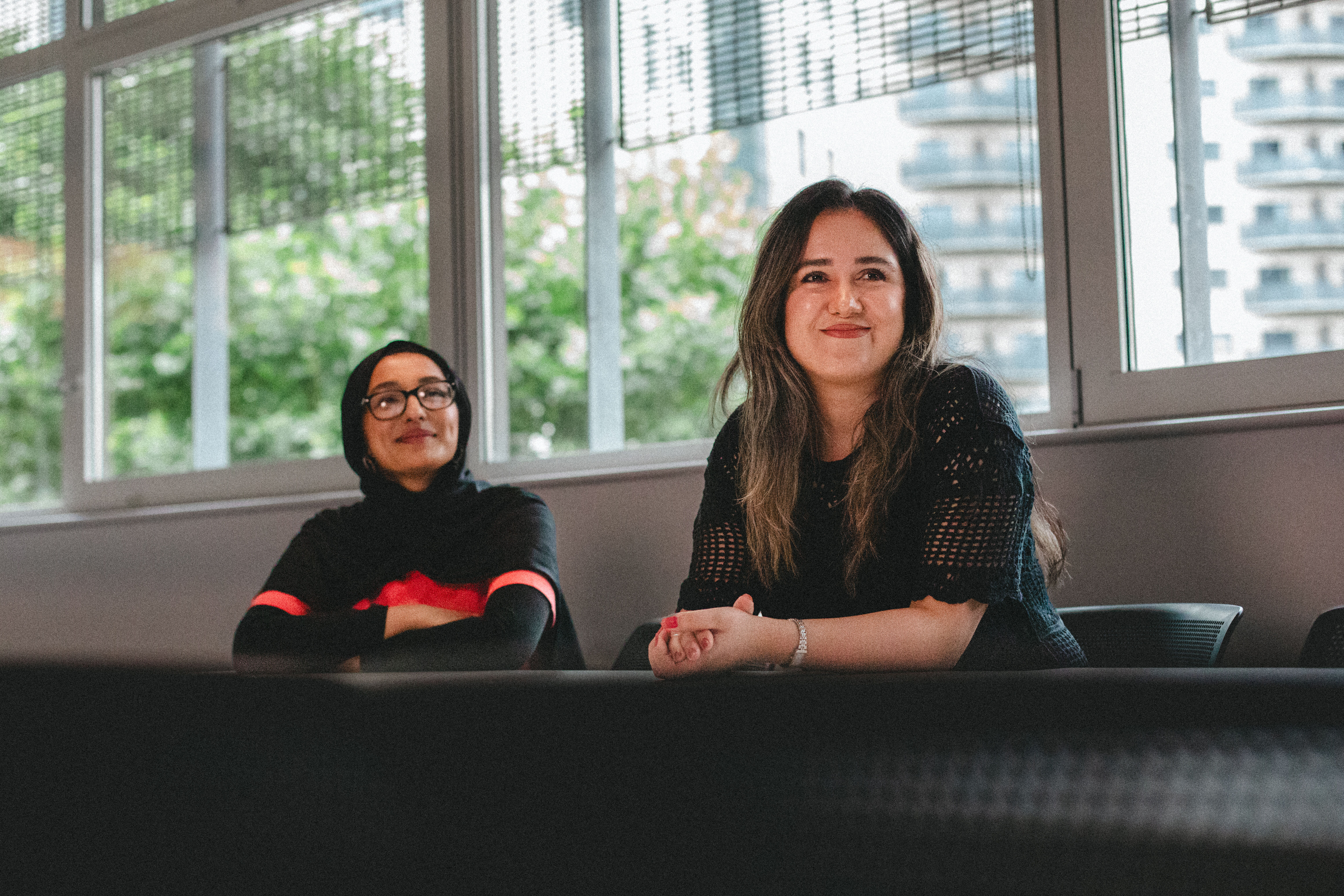 Two students sat smiling together