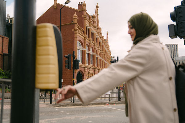 A student crosses the road outside of city centre campus