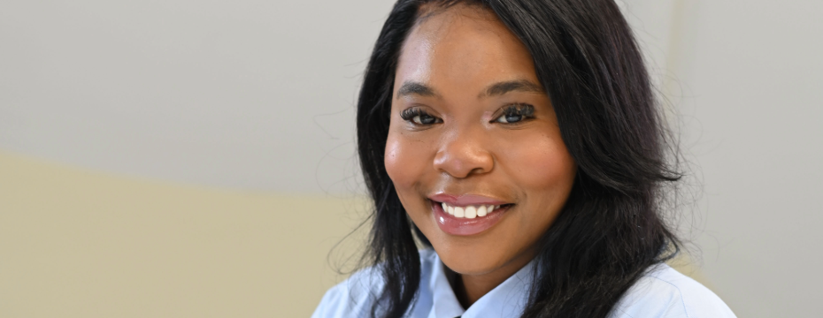 A lady smiling while wearing a blue shirt