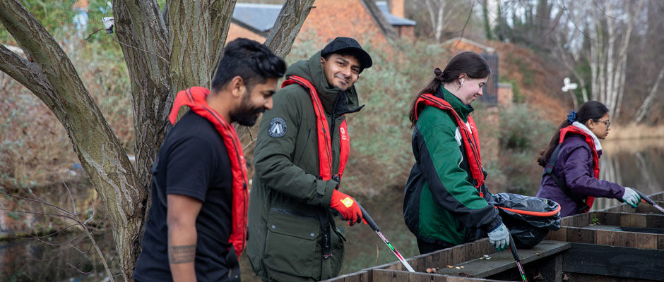 Four students litter pick along the canal in Birmingham city centre