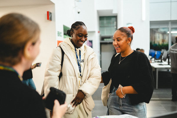 Two students talk to a support stand at the BCU's welcome week fair