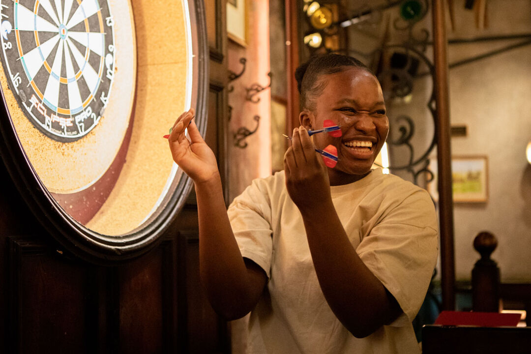 Student celebrates whilst playing darts