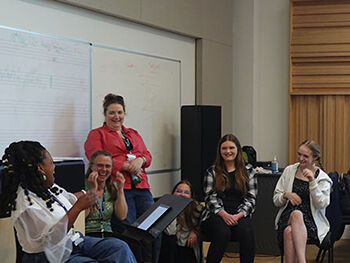 Youngsingers members in workshop sitting in a  group looking happy and laughing